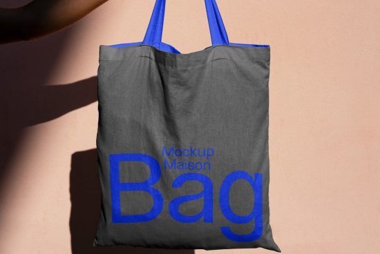 Stylish tote bag mockup with blue handles on a pink background, showcasing a bold font design, ideal for designer templates and graphics.