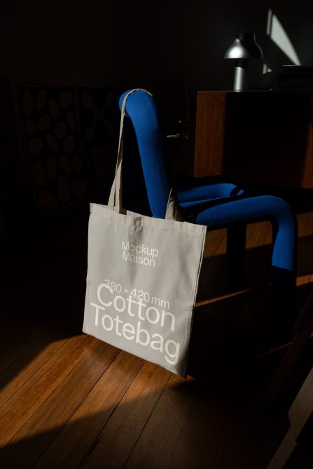 Designer tote bag mockup on chair in natural lighting. Ideal for presentations, showcasing font, graphics, and branding design.