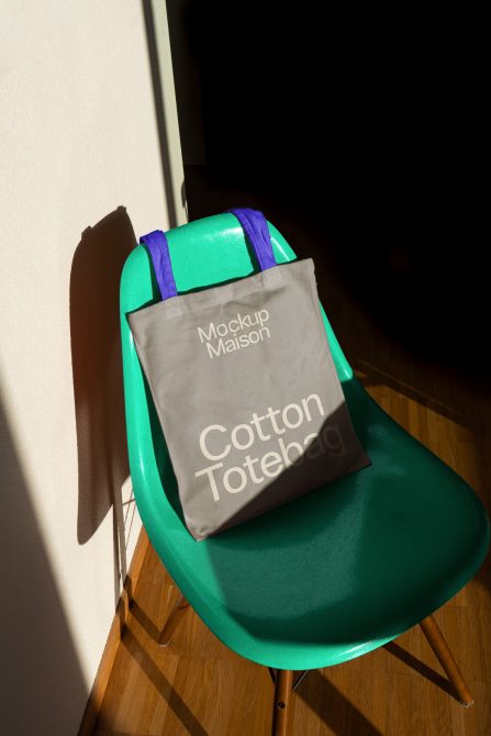 Green chair with a printed tote bag mockup in natural light for product presentation, ideal for designers to showcase tote bag designs.