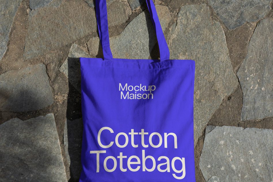 Blue cotton tote bag mockup on stone background, realistic template for designers, editable product display.