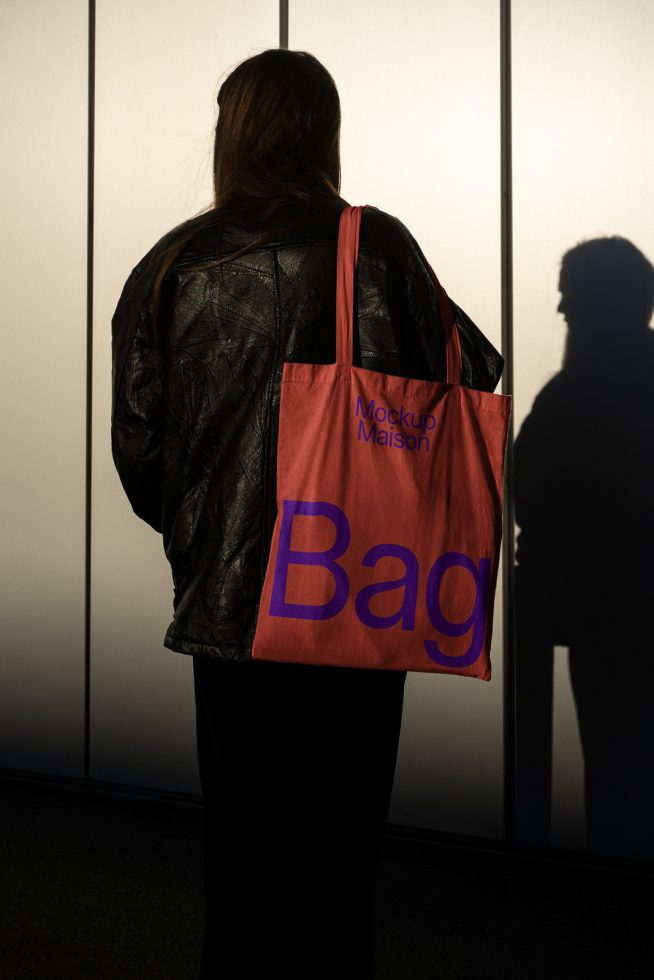 Woman holding tote bag mockup with unique shadow play, ideal for showcasing designs in a realistic setting, perfect for designers.