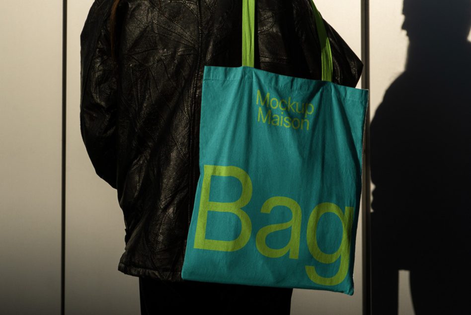 Backshot of turquoise tote with yellow Bag text on shoulder