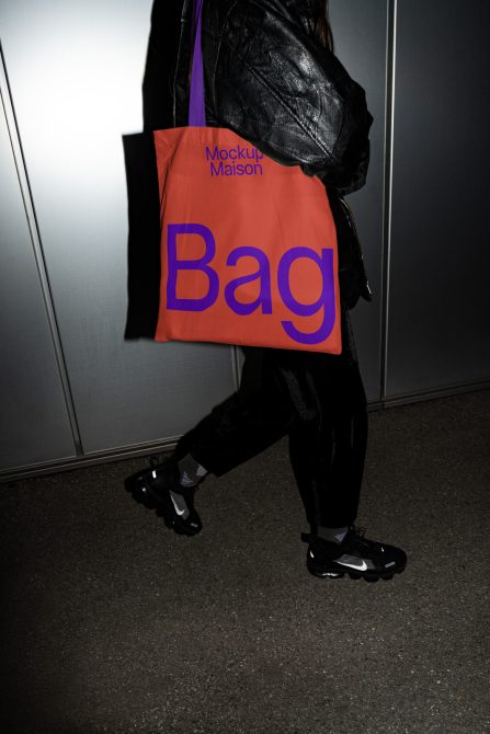 Person holding a tote bag mockup with bold typography, ideal for showcasing design work, fashion accessories, and branding graphics.