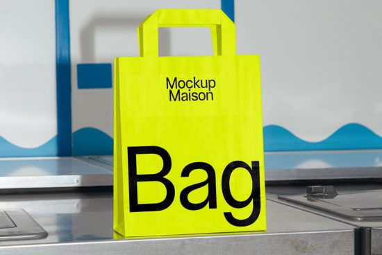 Bright yellow shopping bag mockup with bold black text on industrial counter for design presentation, suitable for graphics and templates.