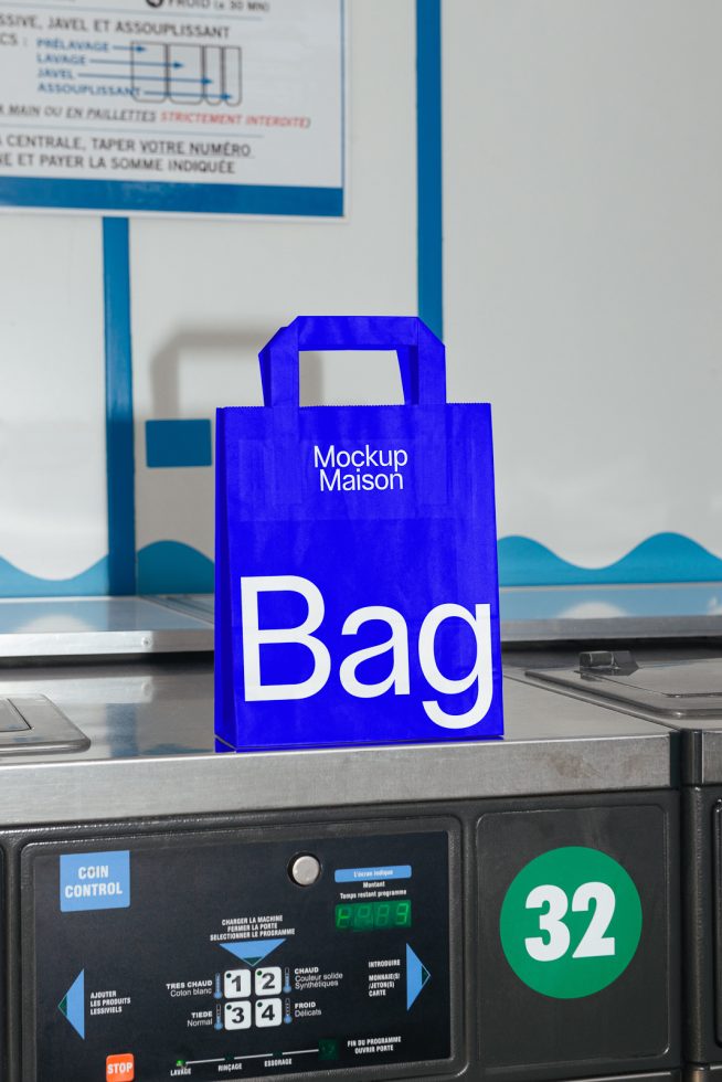 Blue shopping bag mockup on laundromat counter for design presentation, realistic retail packaging, eco-friendly tote, template display.