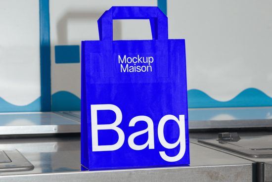 Blue shopping bag mockup with white text standing on a store checkout counter, ideal for designers to showcase branding designs.