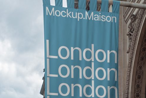 Banner mockup hanging on a classic building featuring bold typography with the word "London" repeated, clear sky backdrop, perfect for designers.