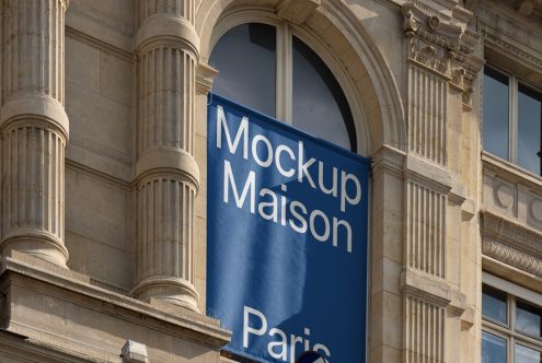 Banner mockup on classic building facade, clear sky, suitable for design presentations and branding, Parisian architecture backdrop.