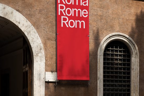 Red banner with text 'Roma Rome Rom' hanging on historical building wall next to arched entrance and window, ideal for mockups and graphic design.