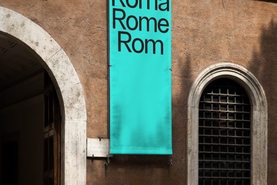 Turquoise banner mockup with bold typography hanging on an ancient building wall, showcasing font design and outdoor display.