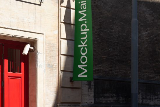 Green banner with the text Mockup.Mail hanging on a building next to a red door, ideal for mockups category in a design asset marketplace.