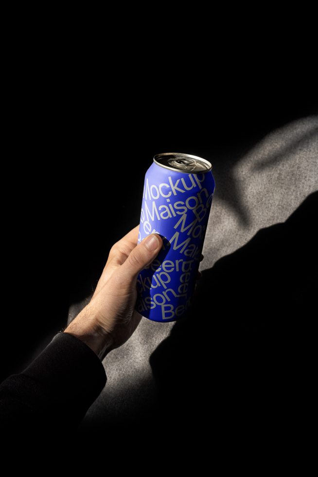 Hand holding a beverage can mockup with dynamic shadows, ideal for product branding presentations and packaging design for designers.