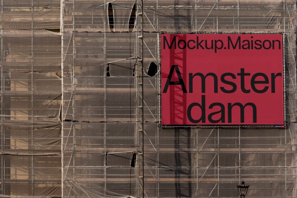 Red billboard on scaffolded building facade showing Mockup.Maison Amsterdam text