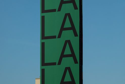 Bold green typography design with repeating "LA" letters against a blue sky, ideal for graphics and font inspiration.