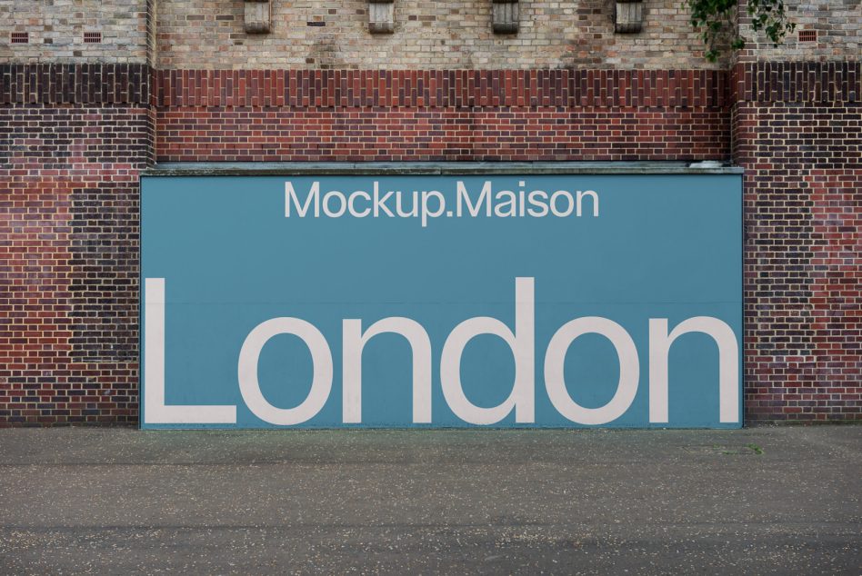 Wide blue storefront hoarding on brick wall with large text
