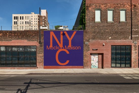 Urban brick building facade with a bold NYC graphic mockup banner design amidst windows and clear blue sky, ideal for designers and templates.