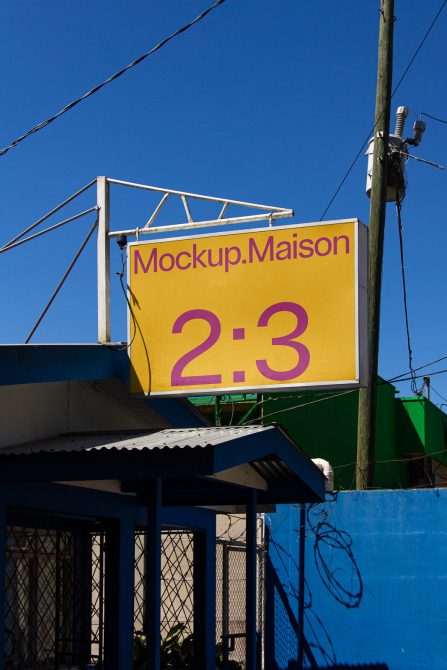 Street sign mounted on pole, yellow background with purple text displaying 2:3 ratio