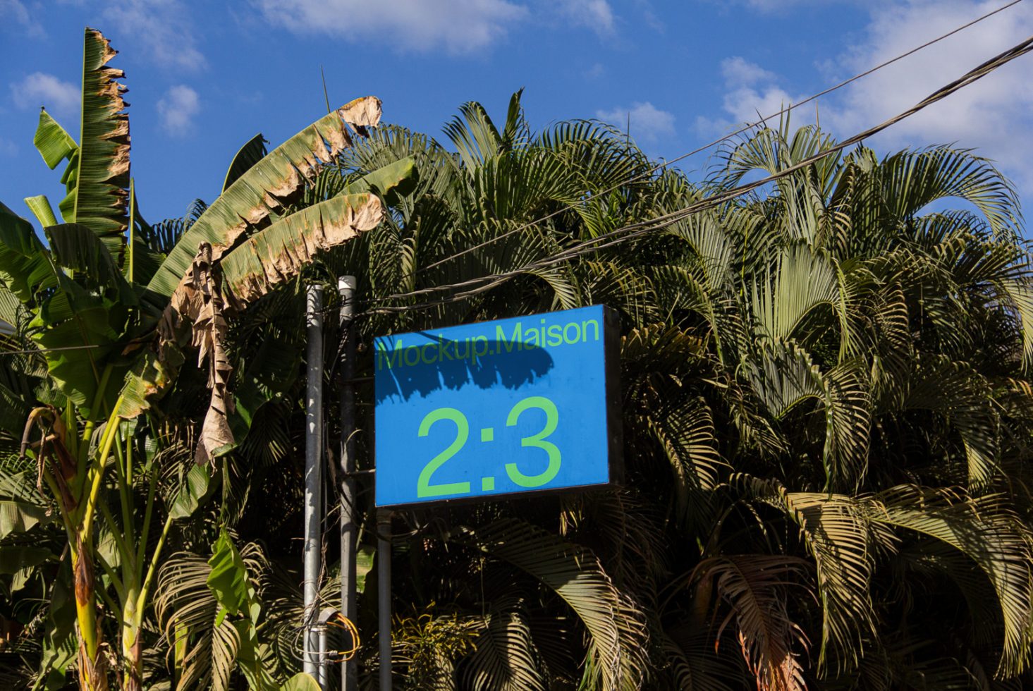 Outdoor billboard mockup with tropical background, clear sky, and lush greenery for realistic advertising design preview.