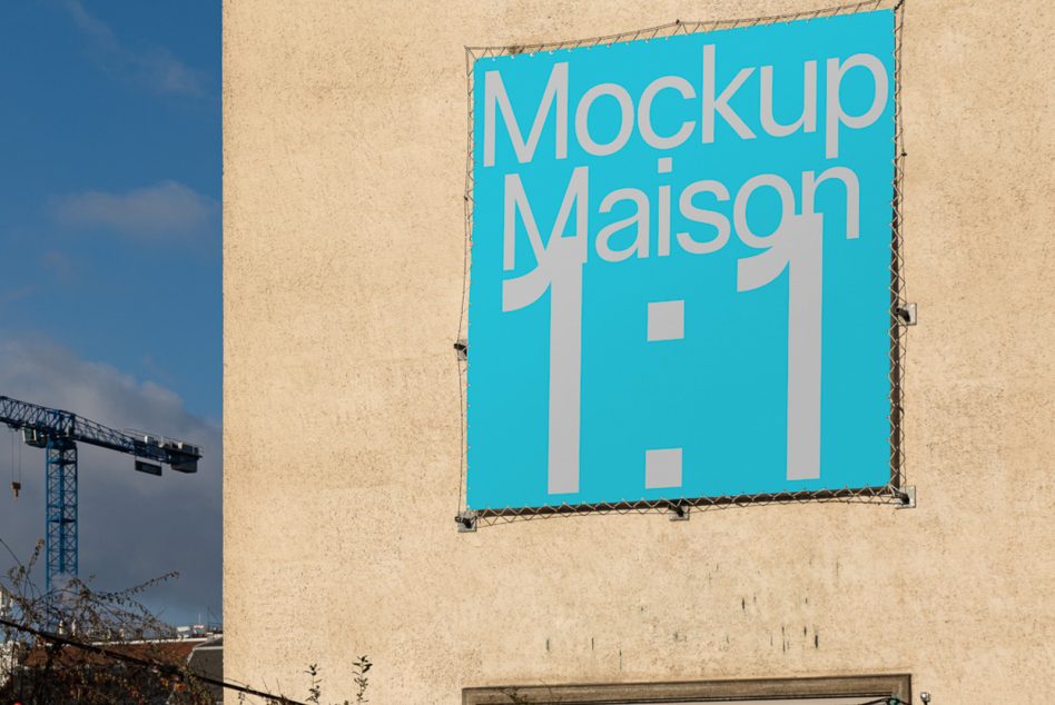 Bright turquoise banner mounted on tan concrete wall displaying Mockup Maison 1 1