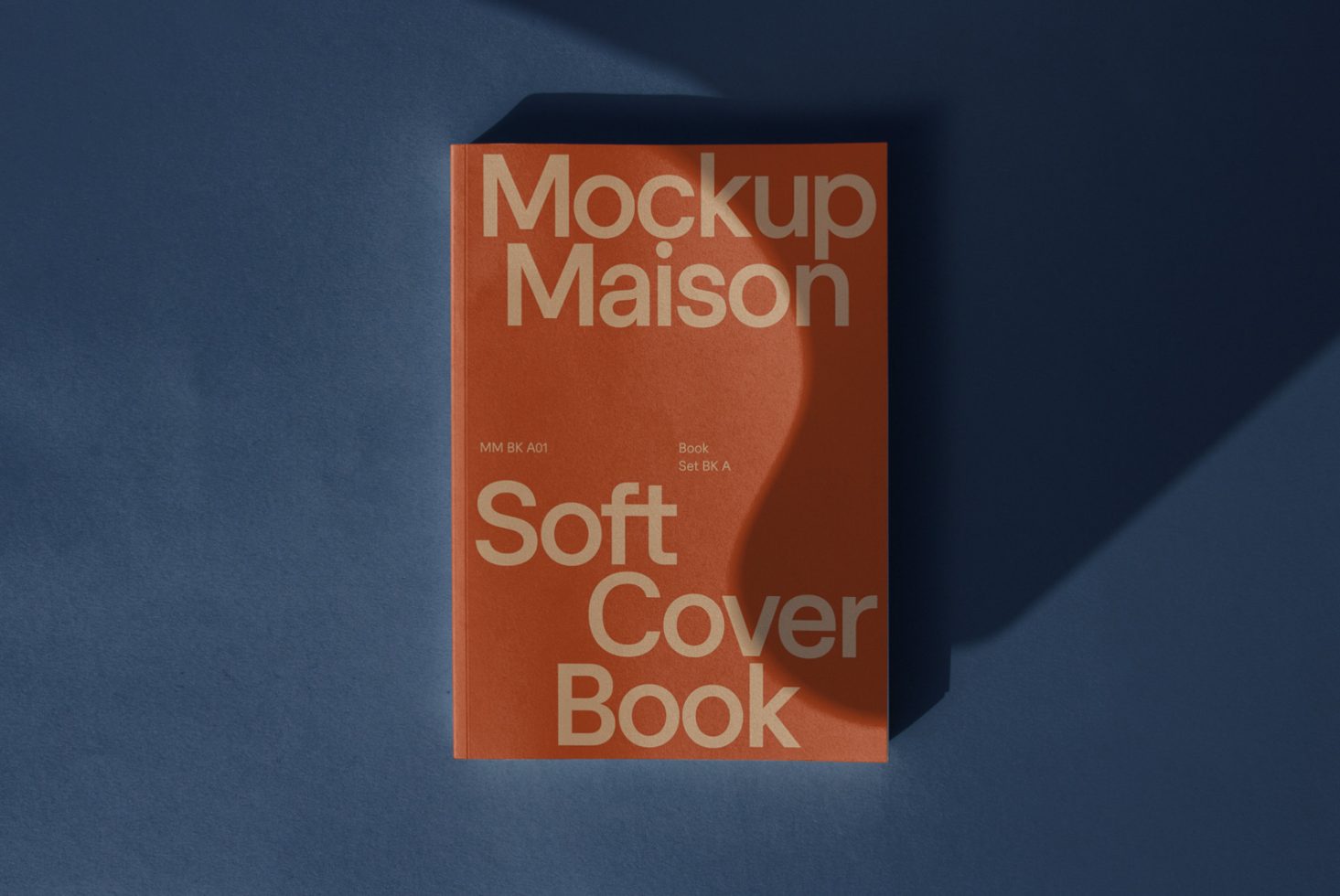 Elegant soft cover book mockup on blue background, orange book with typography, realistic shadow overlay, design presentation.