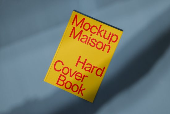 Yellow hardcover book mockup on blue background, angled view, ideal for showcasing cover designs and layouts for designers.