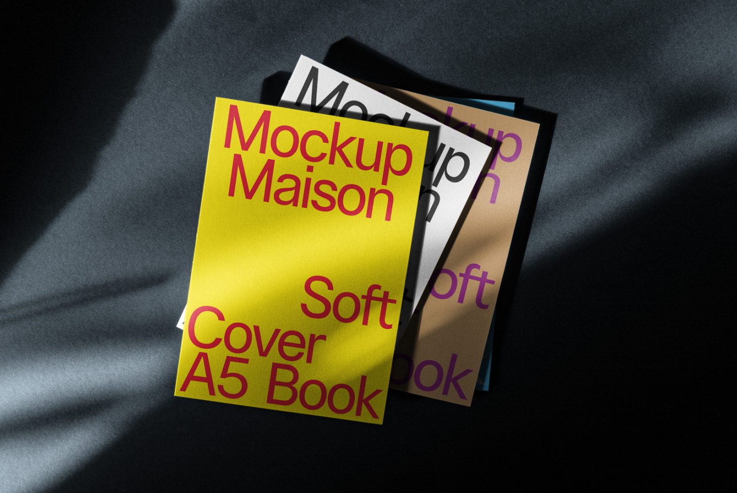 Yellow and multicolored A5 softcover book mockups with dynamic shadows on dark surface, realistic presentation for design showcase.