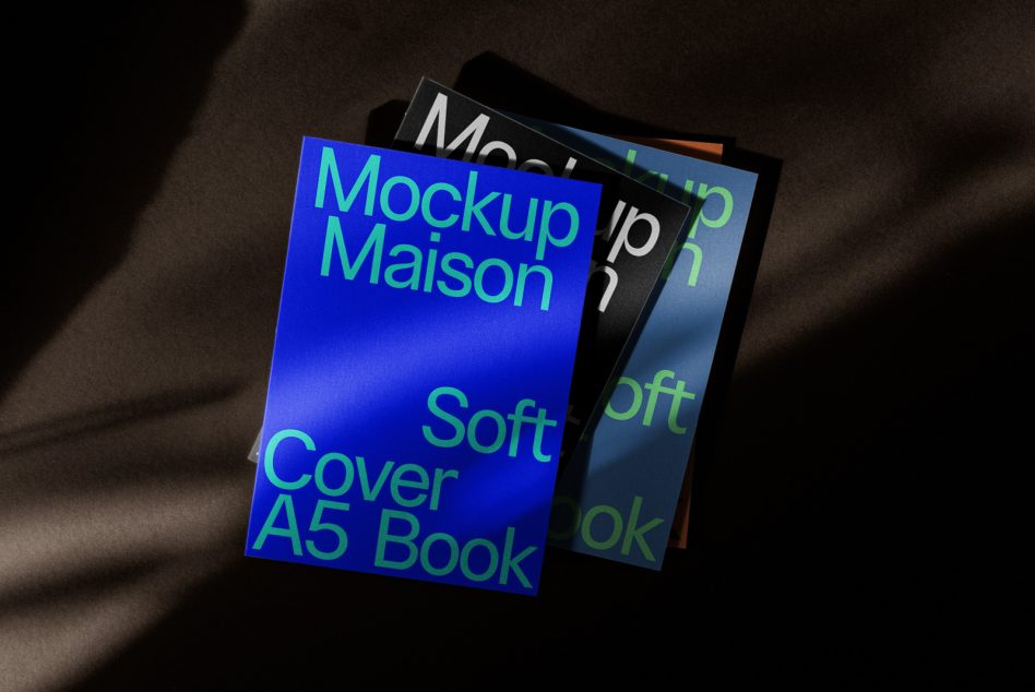 Mockup of A5 book covers in a pile with dramatic shadows, perfect for designers to showcase work on digital marketplace.