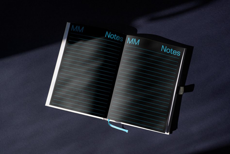 Open notebook with teal text lines, MM Notes header on dark cover