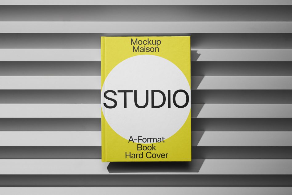Yellow A-format hardcover with STUDIO text on white circle, striped background showing
