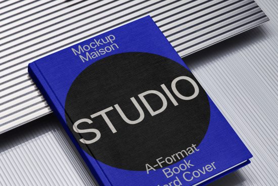 Hardcover book mockup on striped surface with title STUDIO, ideal for showcasing book designs and cover art for designers.