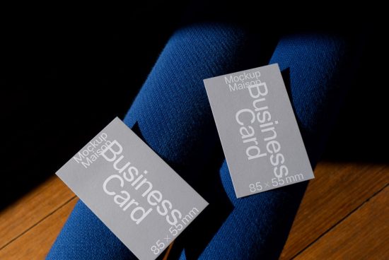 Business card mockup on blue fabric surface, showcasing design and size details, ideal for designer presentations and branding assets.