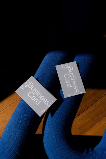 Elegant business card mockup on blue fabric with contrasting shadows perfect for presentation and design showcases.