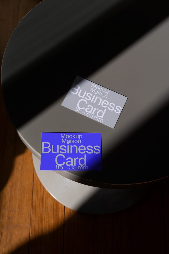 Elegant business card mockup on a metallic table with natural lighting, showcasing design potential for creatives and designers.