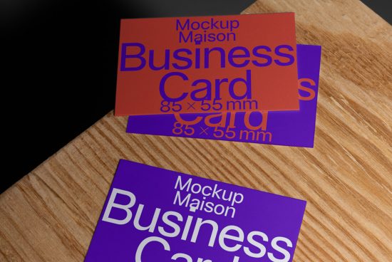 Business card mockup with purple and red cards lying on a wooden surface, showcasing design and size details for graphic templates.