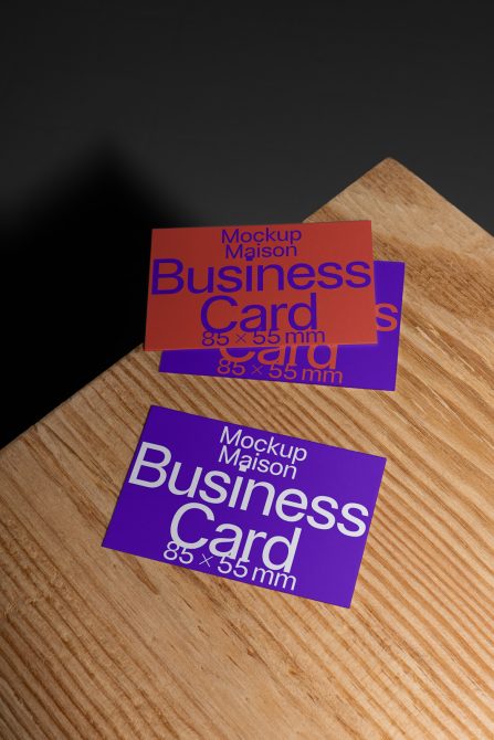 Professional business card mockup on a wooden surface with a dark background, showcasing two cards with editable design for designers.