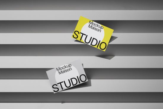 Creative business card mockup with two angled cards on striped shadowed background, demonstrating design presentation.
