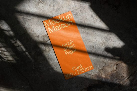 Realistic paper card mockup with dynamic shadows on textured concrete floor for presentation and portfolio design.