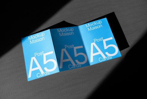 Mockup of three A5 cards displayed in overlapping fashion with elegant shadows on a gray background, ideal for presentations and portfolios.