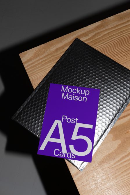 A5 card mockup on wooden surface with bubble mailer, showcasing modern design, ideal for graphic presentations and advertising layouts.