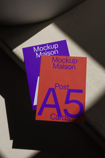 ALT: A5 postcard mockups in purple and orange with shadows, placed on a textured surface, showcasing elegant design presentation for digital asset marketplace.