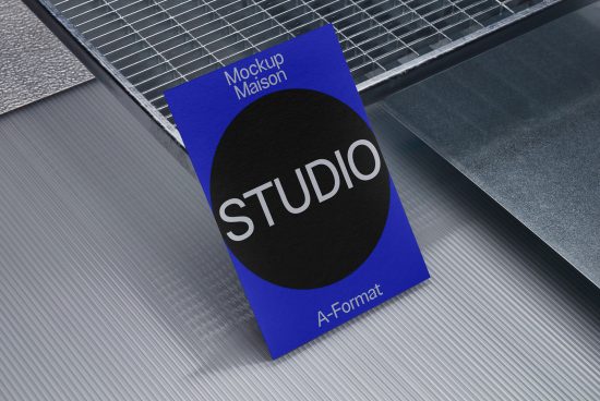Professional blue business card mockup with black circle design element on a textured metallic background, ideal for designers and studios.