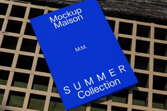 Blue book cover mockup on textured backdrop with 'Mockup Maison Summer Collection' text for graphic design presentation and portfolio display.