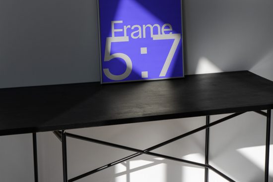 Frame mockup on wooden table against a grey wall with natural shadows, 5:7 ratio, minimalist design, modern interior, digital asset for designers.