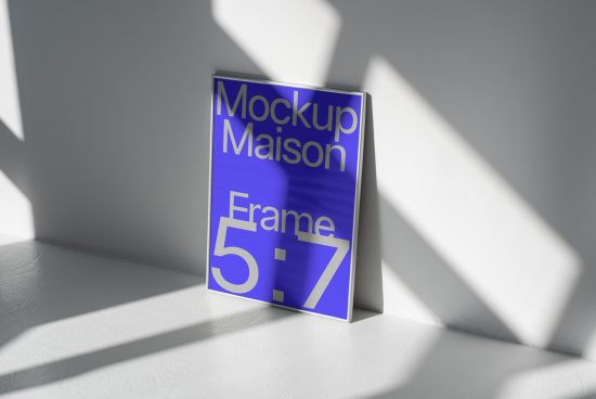 Mockup of a 5x7 frame leaning against a white wall with dynamic shadows, ideal for presenting design work and graphics.