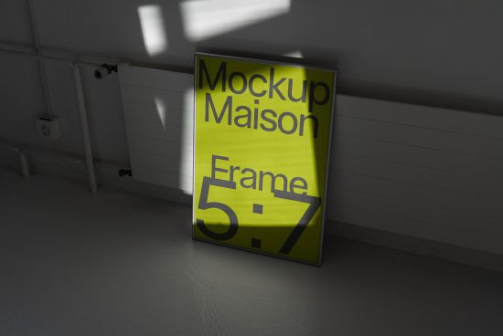 Realistic poster frame mockup in shadowed room leaning against wall, perfect for presentations and portfolio display.