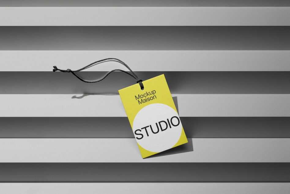 Yellow tag mockup with black cord against a striped background, ideal for branding presentations and design showcases in graphics category.