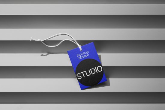 Blue tag mockup with white string on striped background, labeled Studio in bold, ideal for branding designs for digital marketplace.