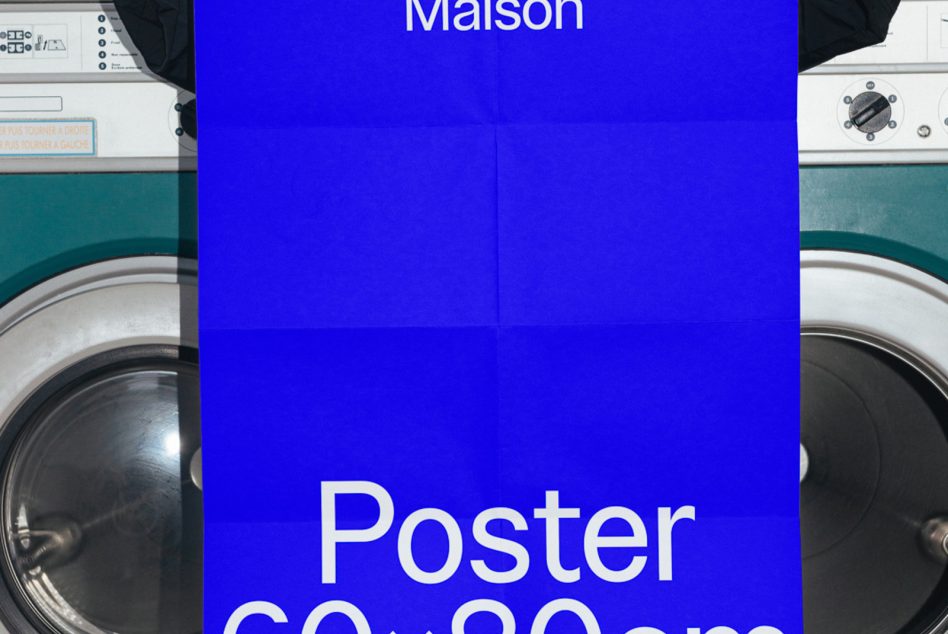 Blue poster mockup design partially visible with text, against laundry machines, showcasing realistic design setting for branding presentations.