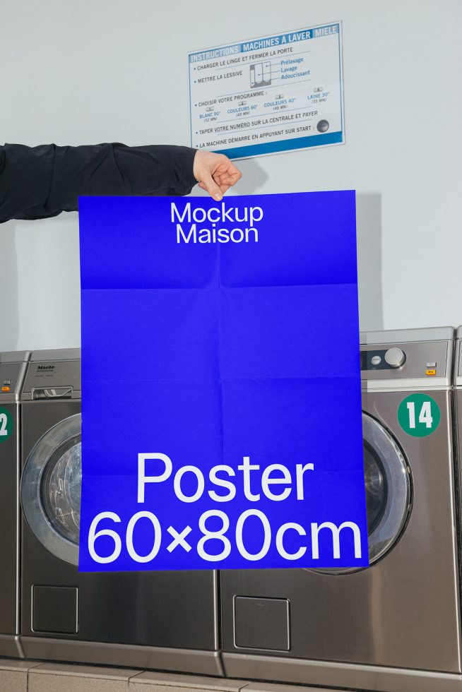 Realistic poster mockup in laundry room environment, showing a person holding up a 60x80 cm blue poster, suitable for showcasing design work.