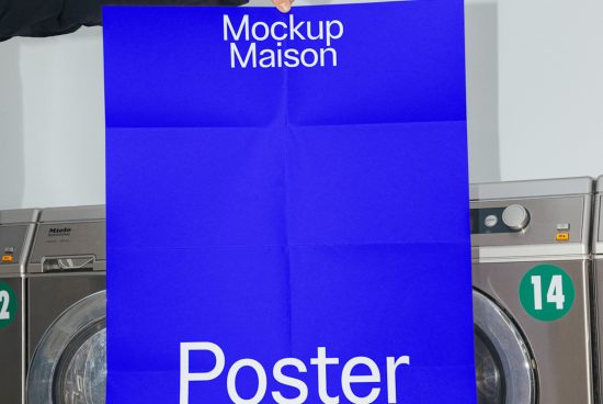 Person holding a folded blue poster mockup in a laundromat, ideal for design presentations and portfolio showcases.